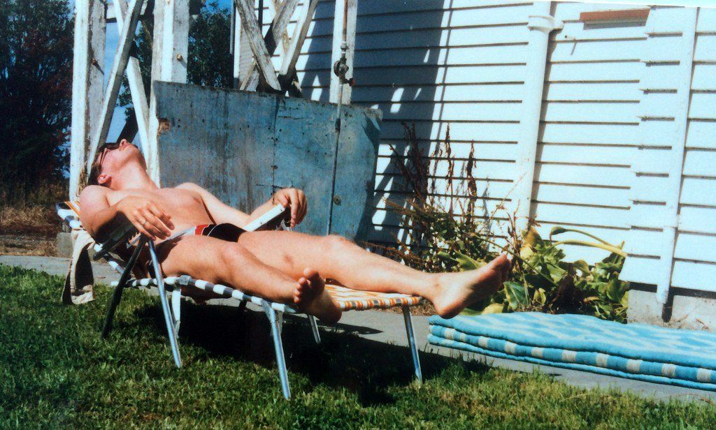 Wife sunbathing back yard